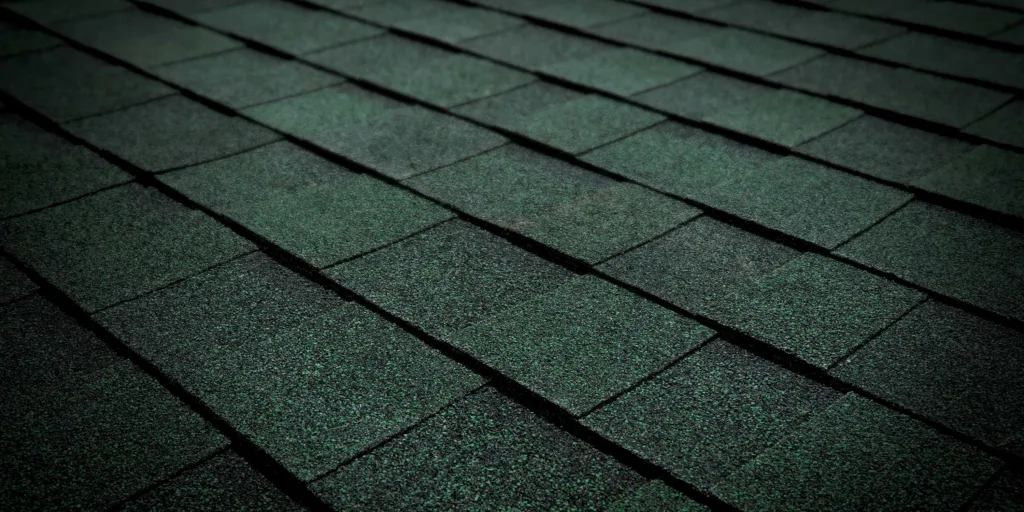 Asphalt shingles in a rustic evergreen color, ideal for a long-lasting and attractive roof.