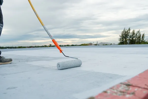 Commercial roof waterproofing being applied by professionals.